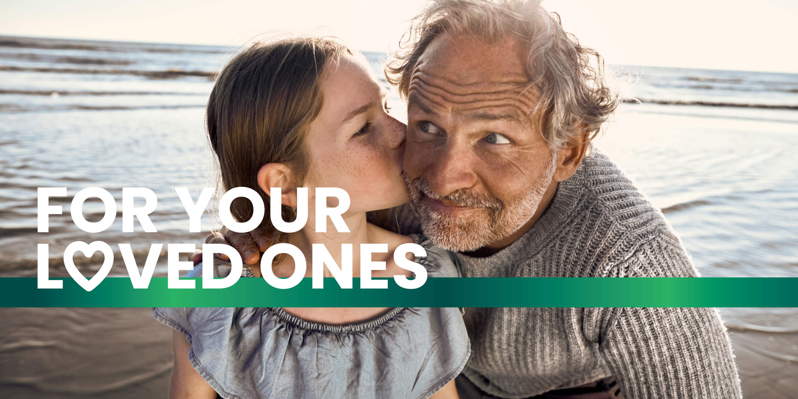 Young girl kissing her grandfather on the cheek at the beach, with text overlay 'For Your Loved Ones.'
