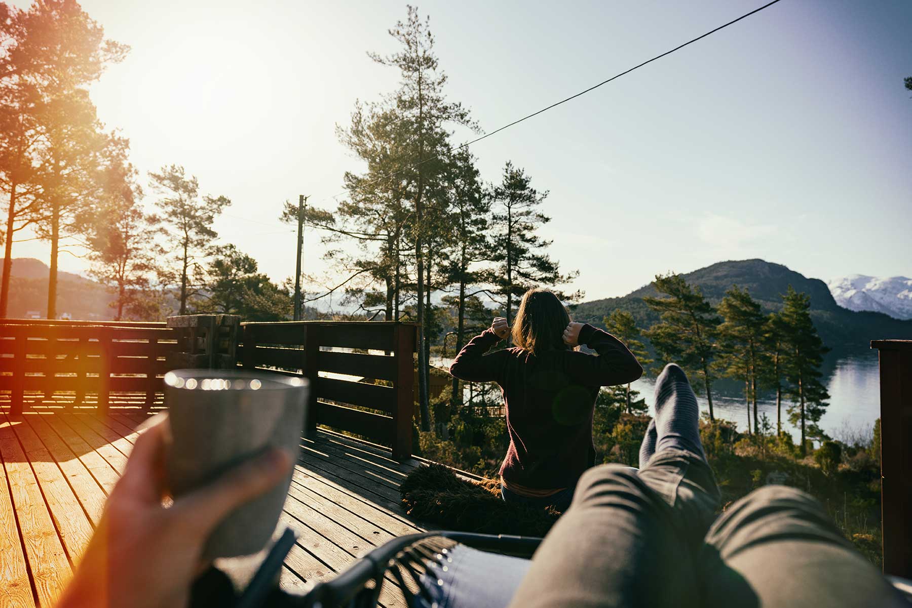 Young couple relaxing on the terrace in nature with a lake view