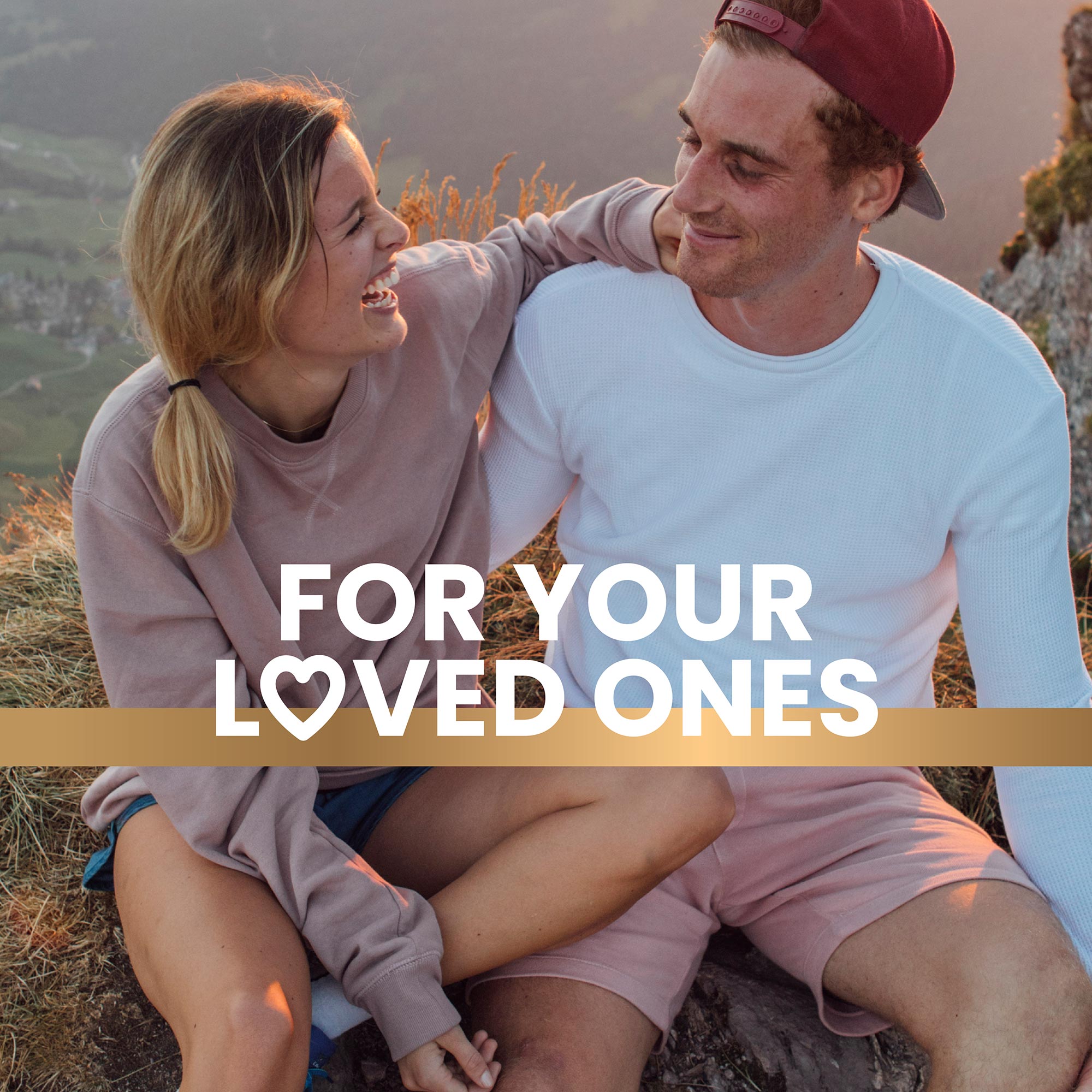 Young couple sitting on a rock on the hill happy enjoying life promoting a healthy lifestyle with Frisk supplements text overlay reads “For your loved ones”