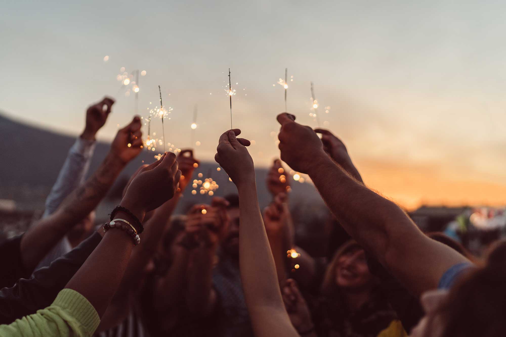 Group of happy people holding sprinkles up in the air