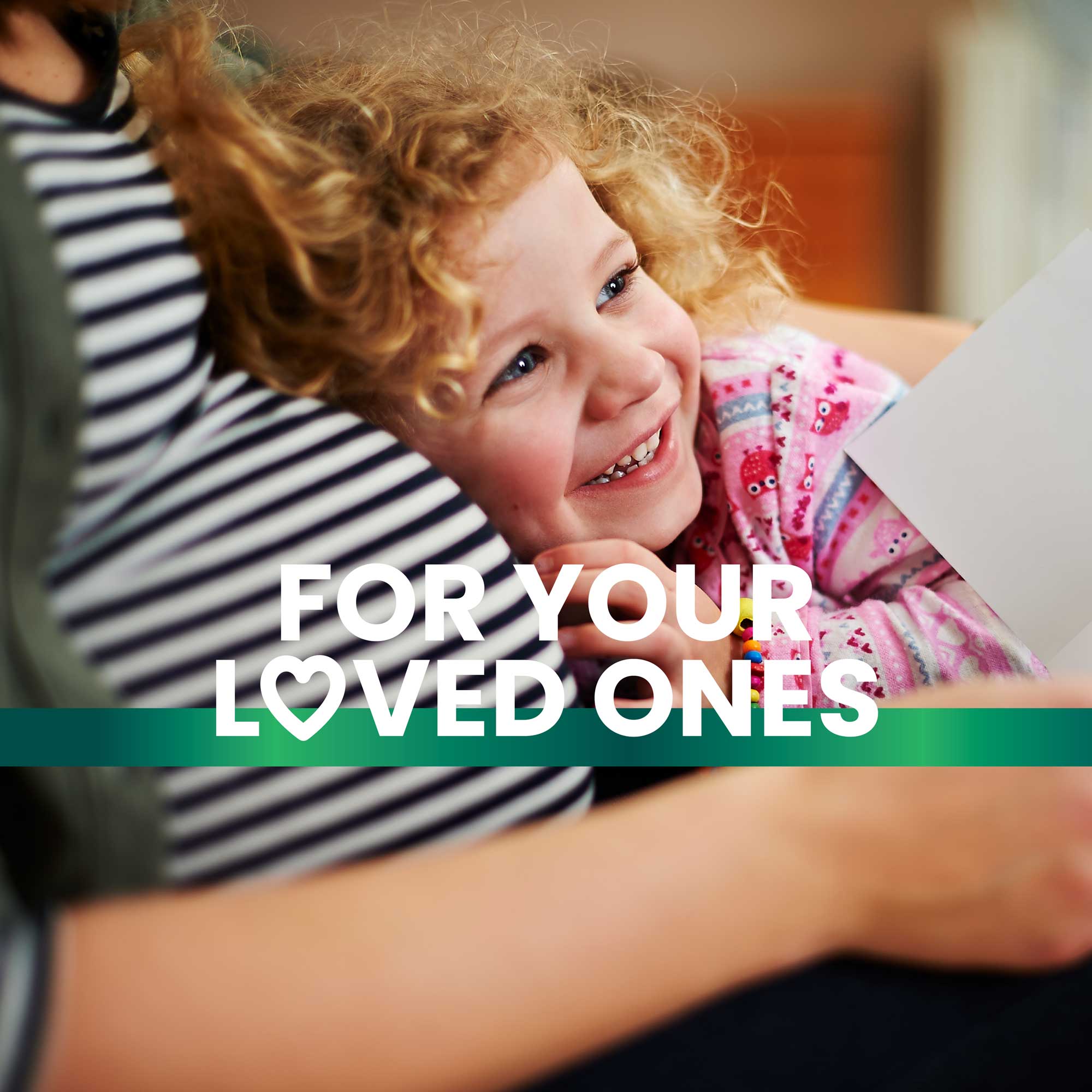 A little girl rests her head on her mom’s pregnant belly as they read a book together, showcasing a tender bonding moment and promoting a healthy lifestyle with Frisk supplements. Text overlay reads "For your loved ones."